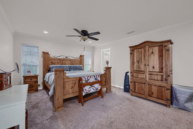 Bedroom with light colored carpet, ornamental molding, a ceiling fan, and recessed lighting | Image 16