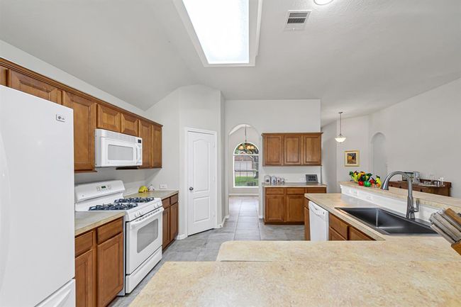 Delightful kitchen with a corner pantry offers tons of cabinets for storage and counter space. | Image 9