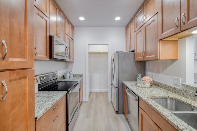 Kitchen with appliances with stainless steel finishes, light wood-style flooring, light stone countertops, and recessed lighting | Image 5
