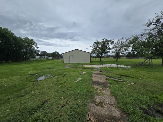 View of grassy yard with a pole building and an outbuilding | Image 24