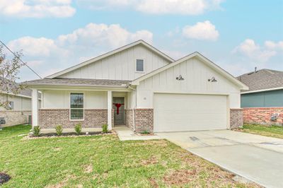 Welcome to 44 Road 5102A in Cleveland, TX! This charming farmhouse-style home captivates with its inviting exterior. The extended front porch creates a warm and welcoming atmosphere, perfect for relaxing evenings or enjoying a cup of coffee in the morning. | Image 1