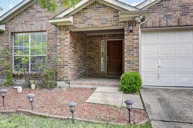 Doorway to property featuring brick siding and a garage | Image 4