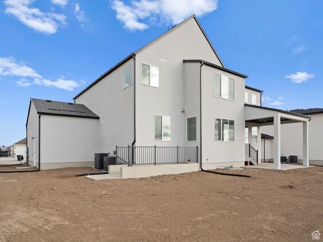 Back of property with central air condition unit, stucco siding, and a patio | Image 26