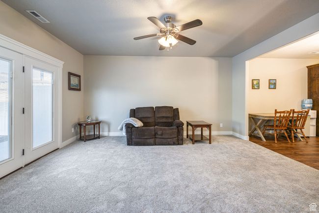 Living area featuring dark colored carpet and ceiling fan | Image 5