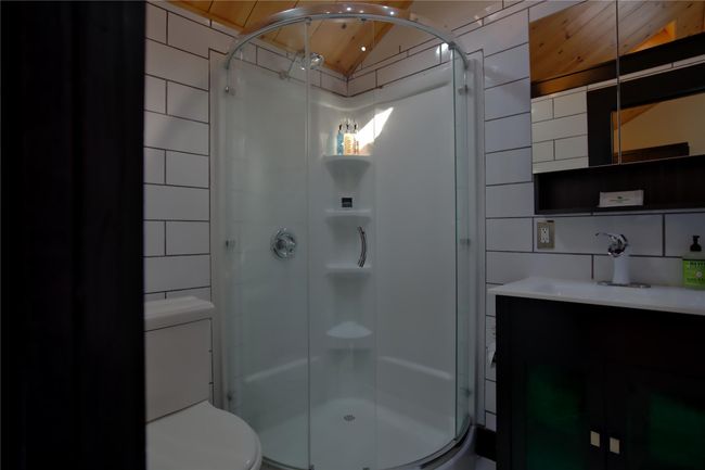 Full bathroom featuring toilet, vanity, tile walls, and a shower stall | Image 5