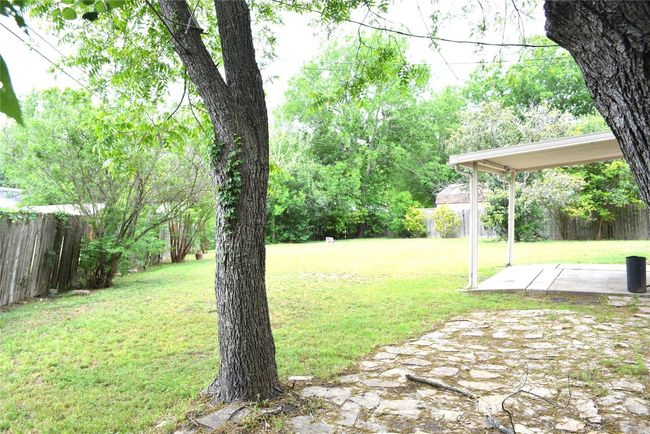 Fenced backyard with a patio | Image 10