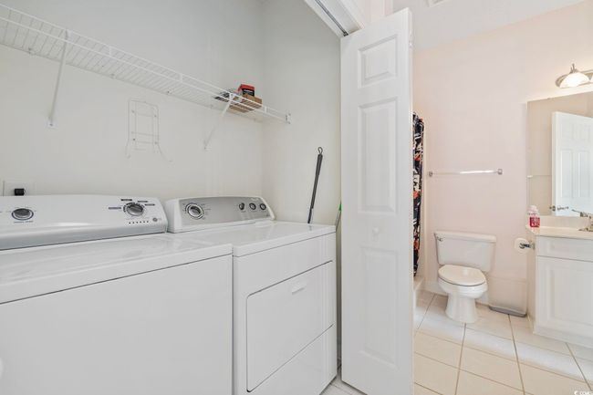 Laundry room featuring washer and clothes dryer and light tile patterned floors | Image 16