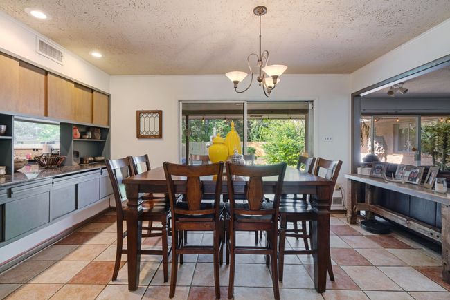 Dining space featuring a textured ceiling, a chandelier, recessed lighting, and light tile patterned flooring | Image 9