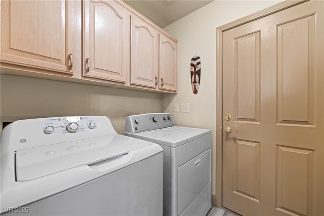 Washroom featuring washing machine and clothes dryer and cabinet space | Image 27