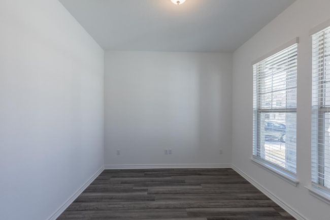 Empty room with baseboards and dark wood finished floors | Image 5