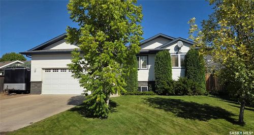Exterior featuring white siding, a dark roof, and a two-car garage | Card Image