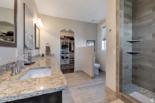 Full bathroom with a spacious closet, a sink, toilet, and wood finished floors | Image 24