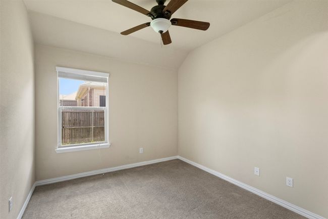 Carpeted empty room featuring a ceiling fan and vaulted ceiling | Image 26