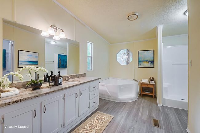 Bathroom featuring crown molding, wood finished floors, a bath, vanity, and a shower stall | Image 19
