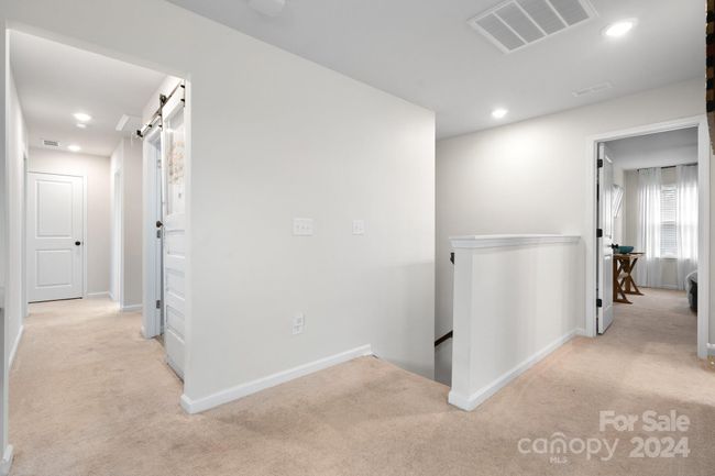 Upper level hallway to left has the laundry room, bedrooms #3 & 4 and the Primary suite. 4th bedroom and full bath on the right. | Image 23