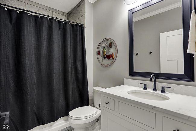 bathroom with vanity, a shower with shower curtain, ornamental molding, and toilet | Image 35