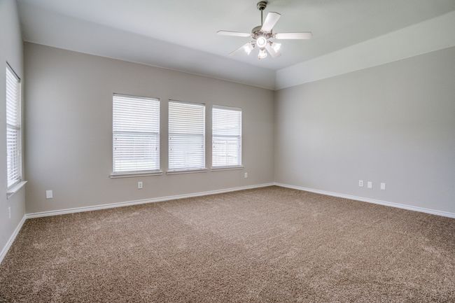 Carpeted empty room featuring ceiling fan and baseboards | Image 11