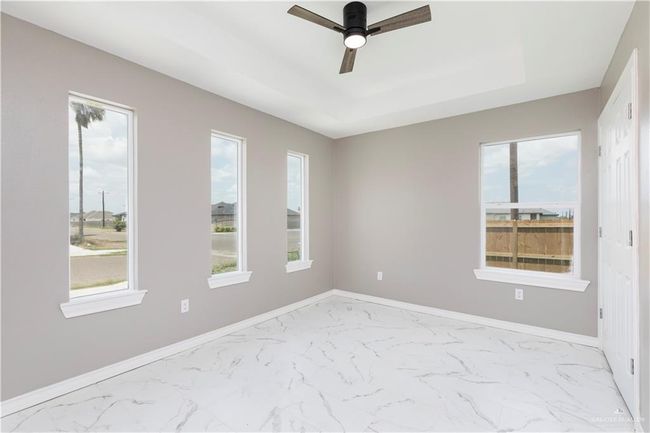 Spare room with a tray ceiling, healthy amount of natural light, and light marble finish flooring | Image 9