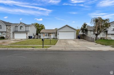 View of front of home featuring a front yard and a garage | Image 1