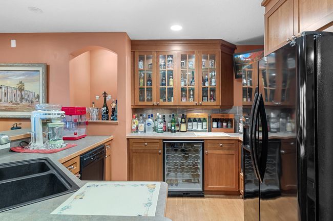 Lower-level recreation room wet bar. Sink, Garbage disposal, dishwasher, wine refrigerator, refrigerator/freezer with icemaker, microwave | Image 45