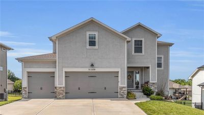 View of front of house with a garage, a front lawn, and central air condition unit | Image 1