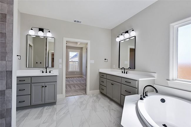 Full bath featuring two vanities, marble finish flooring, a bath, and baseboards | Image 17