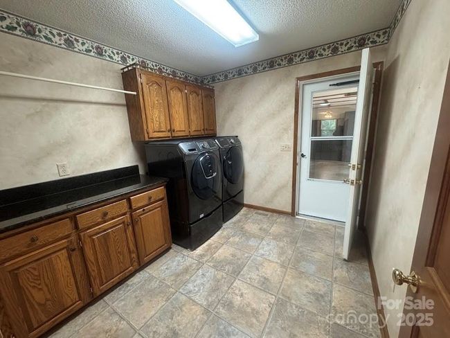 Great size laundry room as you enter from garage with cabinets and folding area | Image 31