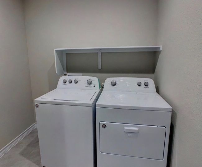 Washroom with washing machine and dryer, baseboards, and laundry area | Image 24