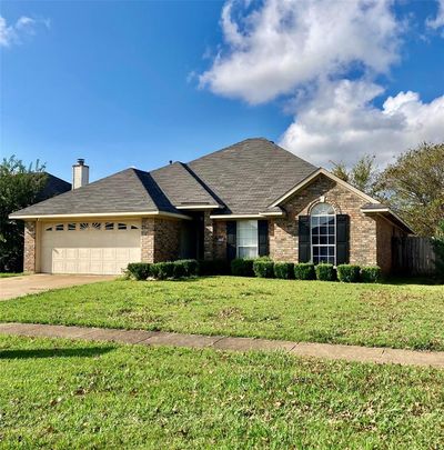 Ranch-style home with a garage and a front yard | Image 1