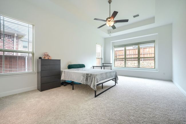 Bedroom with baseboards, a ceiling fan, visible vents, and carpet | Image 16