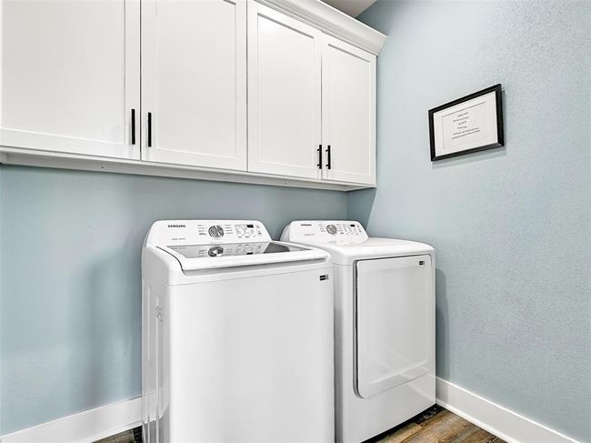 Wash up your towels and swimsuits in this dedicated laundry room that comes complete with a top-load Samsung washer and dryer, plus upper cabinetry for convenient storage. | Image 26