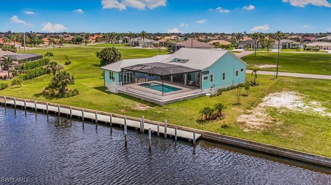 Rear view of house featuring a residential view, a water view, glass enclosure, a yard, and an outdoor pool | Image 39