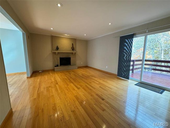 family room with ornamental molding, light wood-type flooring, and a fireplace | Image 17