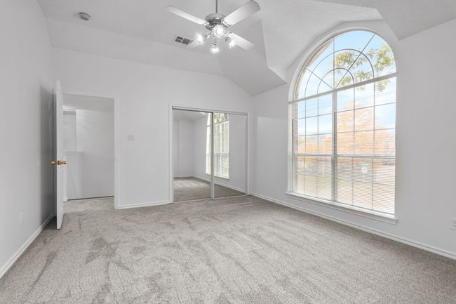 The primary bedroom has a beautiful window and two closets. | Image 24
