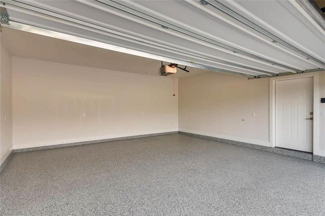 Enormous garage with garage door opener and electric car plug option. Epoxy is an upgrade. | Image 37