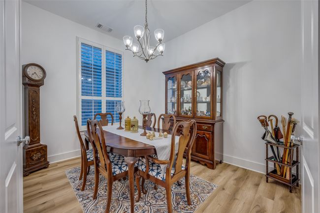 Dining space featuring baseboards, light wood-type flooring, a notable chandelier, and visible vents | Image 4