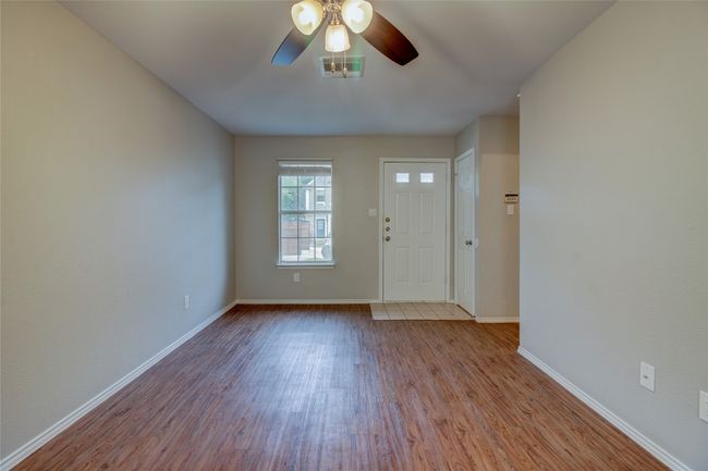 Entryway with wood finished floors, a ceiling fan, and baseboards | Image 8