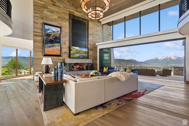 Living area with a high ceiling, hardwood / wood-style flooring, and a fireplace | Image 8