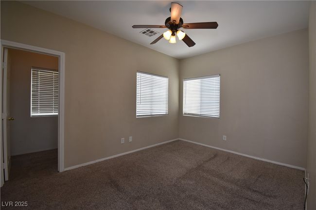 Carpeted spare room with visible vents, a ceiling fan, and baseboards | Image 12