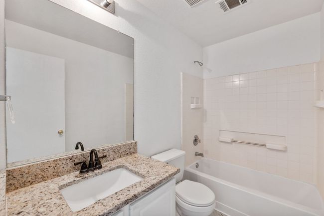 Bathroom with toilet, vanity, and bathtub / shower combination | Image 19