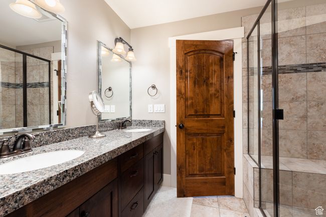 Full bath featuring double vanity, a sink, tile patterned floors, and a shower stall | Image 19