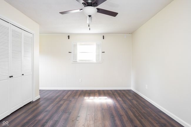 unfurnished bedroom with wood finished floors, a closet, and ceiling fan | Image 25