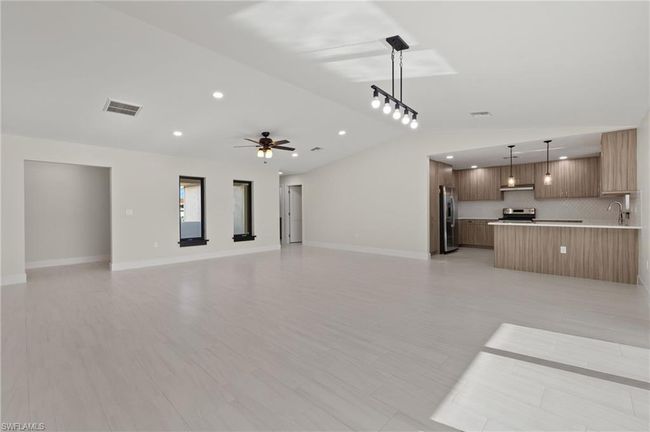 Unfurnished living room featuring sink, light tile patterned floors, and ceiling fan | Image 16