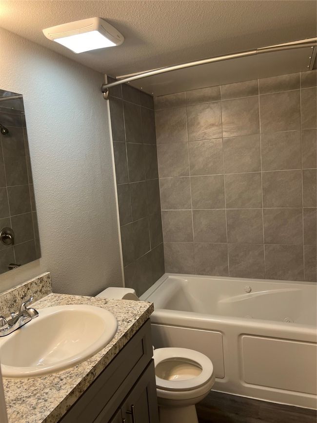 Full bath featuring vanity, toilet, and shower / bath combination | Image 10