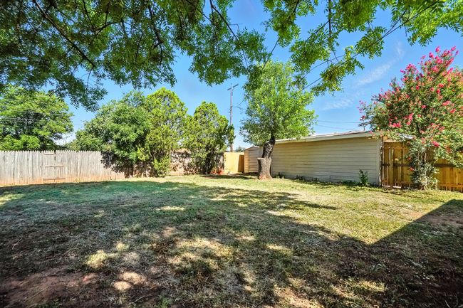Fenced backyard with a shed | Image 25