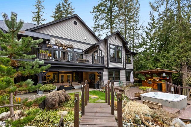 Rear view of property with a hot tub, an outdoor hangout area, a patio, and a wooden deck | Image 34