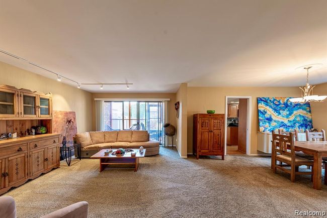 Living area featuring light carpet and a chandelier | Image 11