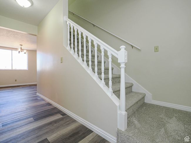 Stairs with a chandelier and wood finished floors | Image 26
