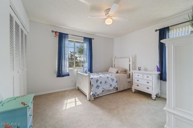 Bedroom featuring light carpet, a closet, a ceiling fan, and a textured ceiling | Image 11