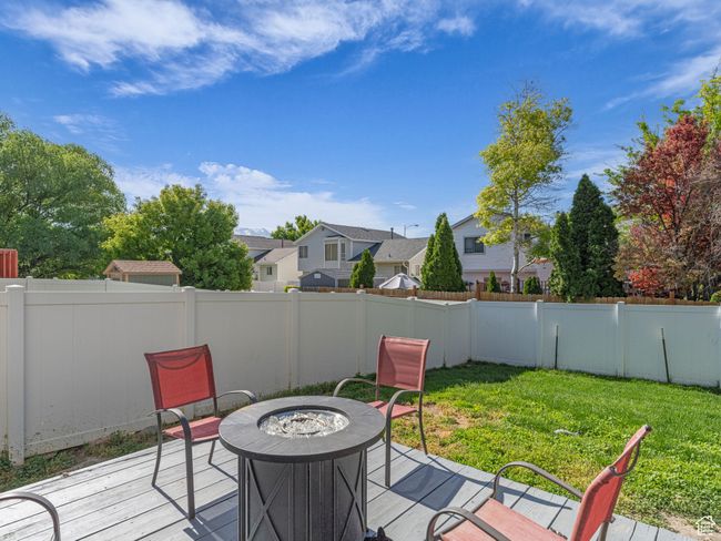 Wooden deck featuring a fire pit and a residential view | Image 34